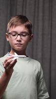 vertical Boy with glasses plays with a toy airplane, lost in imagination and dreaming of flying as a future pilot, embodying adventure and ambition video