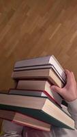 vertical pov First person view Determined student carefully balances a stack of books on a creaky wooden floor, symbolizing the challenges and triumphs of education video