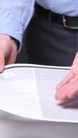 vertical Office worker offering a pen and a document to sign, with ring binders and a daily planner in the foreground, suggesting a business deal or contract. Businessman giving pen and document video