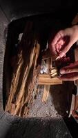 vertical view from above matches in men's hands are preparing to light a fire in a fireplace. preparing a fireplace for kindling. firewood in a fireplace. top view matches video