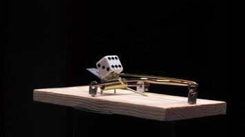 Dice balancing on a mousetrap symbolizing risk video