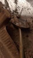vertical irst-person view pov a shovel rakes ashes out of a fireplace. A person cleans a stone from ashes. Ashes are raked into a bucket from a home fireplace. Fireplace maintenance video