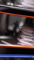 vertical Overflowing office binders stacked high, suggesting a busy administrative environment with a focus on organization and paperwork management. close-up colored binders are stacked video