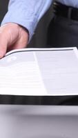vertical Confident businessman explains contract terms at white table, showcasing teamwork and communication in corporate setting. Successful deal negotiation captured video