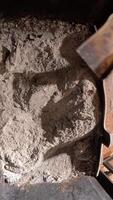 vertical top view. view from inside fireplace. Housekeeper cleans a fireplace filled with ashes using a metal shovel. The process involves removing waste and maintaining a cozy video