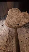 vertical pov first-person view a shovel rakes ashes out of a fireplace. A person cleans a stone from ashes. Fireplace maintenance. a full shovel of cooled ashes video