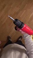 vertical Pov first person view Confident handyman with cordless drill on parquet floor in cozy house, showcasing expertise in construction and renovation tasks video