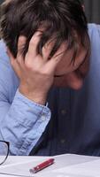 vertical Office worker suffering from headache or stress, sitting at desk with stack of folders and documents, tired businessman having problems at work video