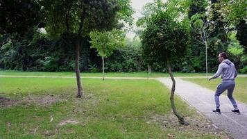 Funny actor tries to hide behind young trees in green park video