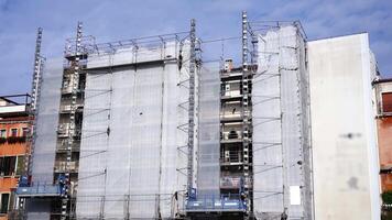 Motion past scaffolding of high building covered with fabric video