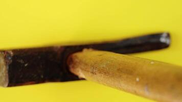 Vintage claw hammer with wooden handle standing on yellow video
