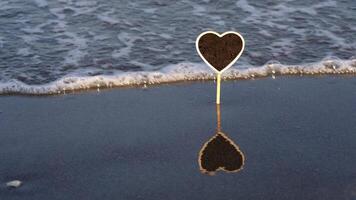 Heart shaped plate with drops and reflection on wet sand video