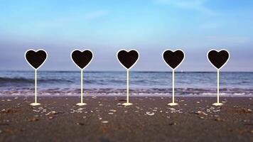 Set of heart shaped plates stands on wet sand of ocean beach video