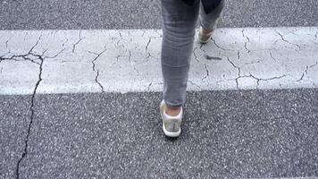 Pedestrian crosses crosswalk with white lines on asphalt video