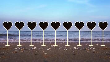 Collection of heart shaped plates on sand of ocean beach video