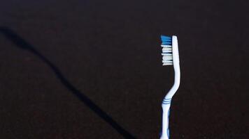 Plastic toothbrush lit by sunlight stands on sea beach video