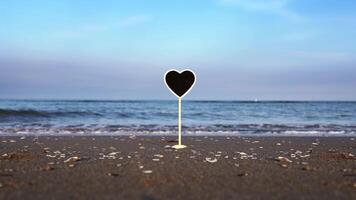 Heart shaped nameplate with space for design on ocean beach video