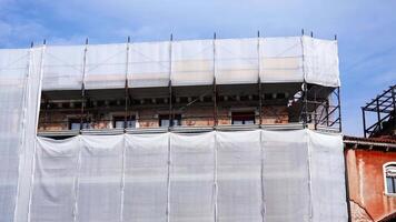 Motion past big square building surrounded by scaffolding video
