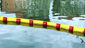 Thin bright red and yellow water dividing bar lies on water video