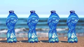 Row of crumpled blue plastic bottles stand on beach sand video