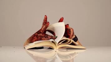 Creepy person hands turn pages of paper book on table video