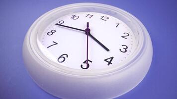 Hour and second hands move on rotating white modern clock video