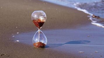 Golden grains in sand timer with glass reflecting sunlight video
