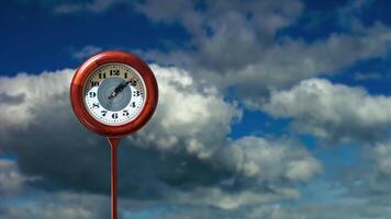 Red clock and space for design against floating clouds video