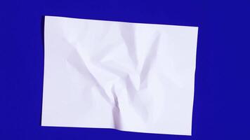 Rumpled paper rolls and unfolds into white smooth sheet video