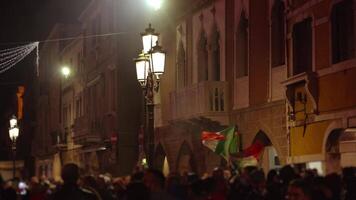 Crowd of people with Italian flags protests on dark street video