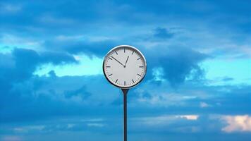 Clock with rotating arrows against sky with fluffy clouds video