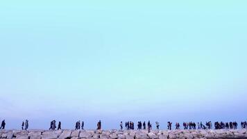 Crowd of different people walk along ancient embankment video