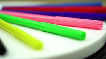 Set of color markers lying on desk on blurred background video