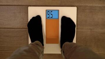 Person feet step on floor electronic scales and digits run video