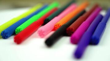Motion past multicolored markers lying on table closeup video