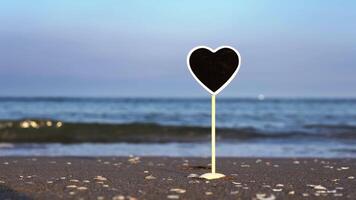 Black heart shaped plate with space for design on sand video