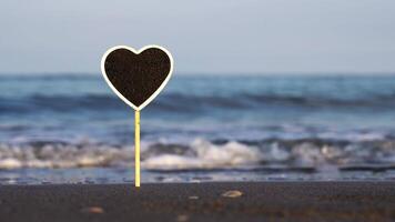 Blank plate with space for text stuck in ocean beach sand video