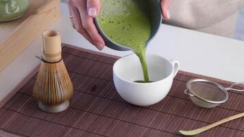 Step by step tutorial making Japanese matcha tea. Step five, pour your matcha tea into the cup, enjoy the drink video