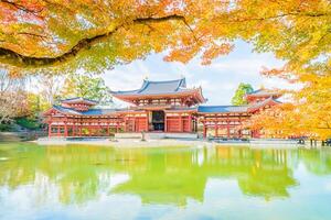 A beautiful asian temple surrounded by trees in the fall photo