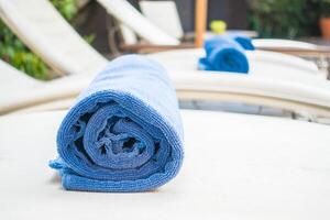 A blue towel is folded on a chaise lounge photo
