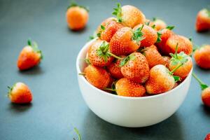 A bowl full of strawberries on a table photo