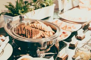 A buffet table with waffles, cookies and other food photo