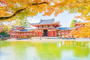 A beautiful pagoda in autumn with a pond in front of it photo