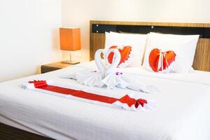 A bed with towels on it and a heart shaped pillow photo