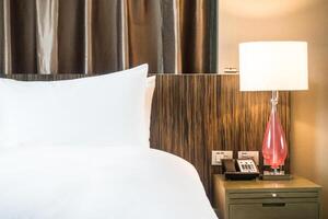 A bed with white sheets and a lamp photo