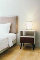 A bed with a nightstand and a lamp on it photo