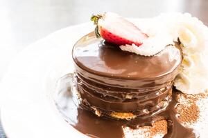 A chocolate cake with whipped cream and a strawberry on top photo