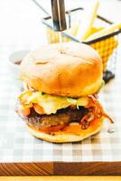 A burger with cheese and bacon on a plate photo