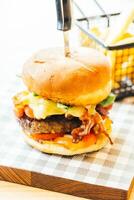 A burger with cheese and bacon on a plate photo