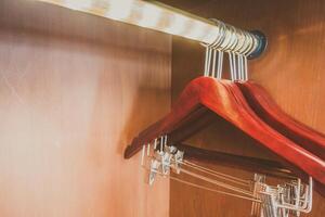 A closet with a hanger and clothes hanging on it photo